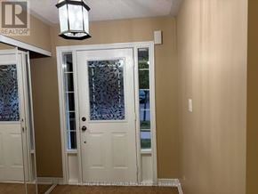 Ajax (South East) townhouse for rent - A white door with a glass panel and a black lantern hanging above it.
