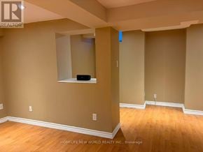 Ajax (South East) townhouse for rent - A room with a wooden floor and a mirror on the wall.