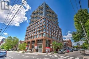 Toronto (Waterfront Communities) condo for rent - A tall building with many windows is located on a street corner.