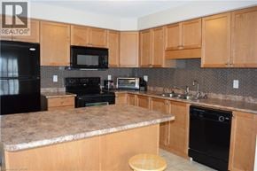 Kitchener townhouse for rent - A kitchen with wooden cabinets and black appliances.