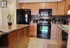 Kitchener townhouse for rent - A kitchen with black appliances and wooden cabinets.