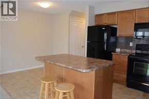 Kitchener townhouse for rent - A kitchen with a black refrigerator and stove.