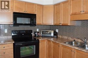 Kitchener townhouse for rent - A kitchen with wooden cabinets and a black oven.