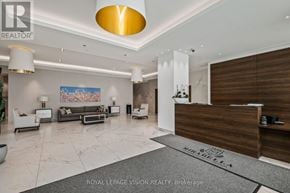 Toronto (South Parkdale) condo for rent - A well-lit, modern living room with a reception desk and a painting on the wall.