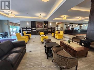 Markham (Milliken Mills East) condo for rent - A living room with a black couch and yellow chairs.