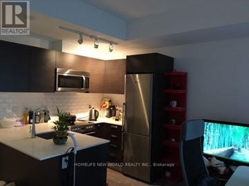 Toronto (Church-Yonge Corridor) condo for rent - A modern kitchen with a refrigerator, microwave, and a TV.