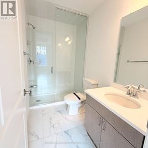 Markham townhouse for rent - A bathroom with a toilet, sink, and shower.