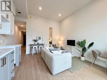 Hamilton (Central) multi-family for rent - A well-lit, modern living room with a grey sofa and a television.