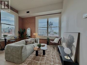 Hamilton (Central) multi-family for rent - A living room with a grey couch, a brown rug, and a painting on the wall.