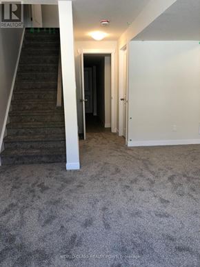 Norfolk (Simcoe) townhouse for rent - A hallway with a staircase and a door.