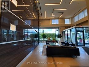 Mississauga (City Centre) condo for rent - A modern office space with a long black couch and a large window.