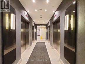 Mississauga (City Centre) condo for rent - A hallway with elevators on both sides and a carpet on the floor.