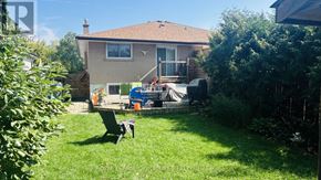 Mississauga (Clarkson) apartment for rent - A house with a patio and a table in the backyard.