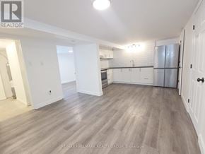 Casselman apartment for rent - A spacious kitchen with white cabinets and a refrigerator.