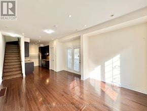 Toronto (Bridle Path-Sunnybrook-York Mills) townhouse for rent - A spacious room with wooden floors and a staircase leading to the upper level.