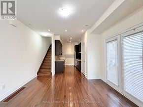 Toronto (Bridle Path-Sunnybrook-York Mills) townhouse for rent - A spacious room with wooden floors and white walls.