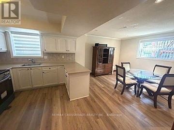 Toronto (Bendale) apartment for rent - A kitchen with a table and chairs in the foreground and a cabinet with a microwave in the background.