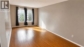 Milton apartment for rent - A room with a wooden floor and a window with black curtains.