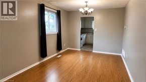 Milton apartment for rent - A room with wooden flooring and a chandelier.