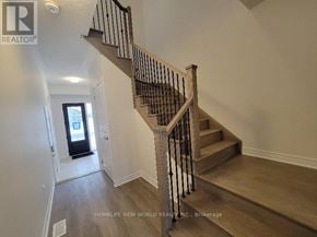 Markham (Middlefield) townhouse for rent - A staircase with a wooden handrail and a landing with a doorway.