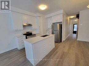 Markham (Middlefield) townhouse for rent - A kitchen with white cabinets and a wooden floor.