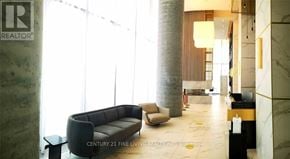 Vaughan (Vaughan Corporate Centre) condo for rent - A living room with a couch, chair, and a table with a bottle on it.