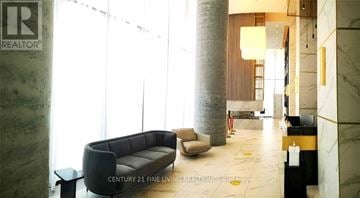 Vaughan (Vaughan Corporate Centre) condo for rent - A living room with a couch, chair, and a table with a bottle on it.