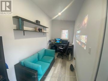 Toronto (Caledonia-Fairbank) apartment for rent - A living room with a blue couch and a desk with a computer.
