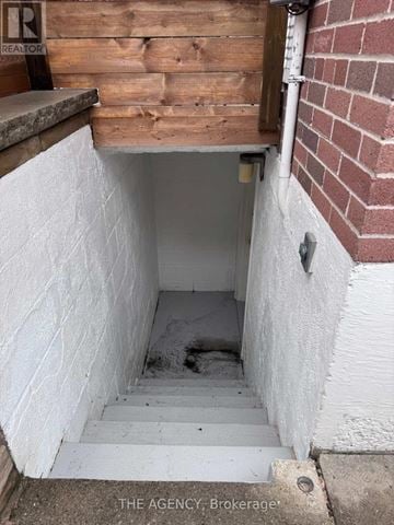 Toronto (Etobicoke West Mall) apartment for rent - A small white doorway with stairs leading down to a dark area.