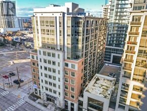 Hamilton (Central) condo for rent - A tall building with a flat roof is surrounded by other buildings.
