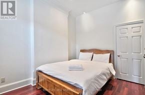 Toronto (Church-Yonge Corridor) townhouse for rent - A bedroom with a bed, pillows, and a wooden headboard.