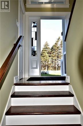 South River apartment for rent - A staircase with a white landing and a view of trees outside the window.