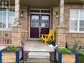 Hamilton (Binbrook) apartment for rent - A front porch with a yellow chair and a purple door.