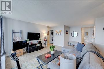 London East (East K) condo for rent - A living room with a grey couch and a black television.