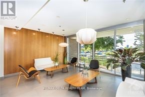 Ottawa condo for rent - A modern living room with a white sofa, wooden chairs, and a large window.
