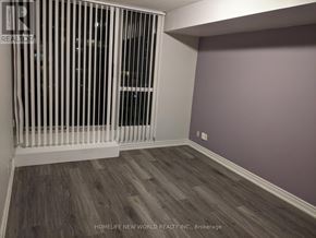 Toronto (Willowdale East) condo for rent - A room with a window covered by vertical blinds and wooden flooring.