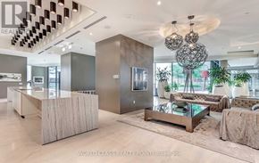 Toronto (Waterfront Communities) condo for rent - A modern office lobby with a reception desk and a large chandelier.