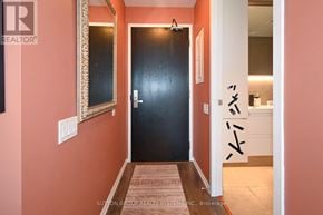Toronto (Waterfront Communities) condo for rent - A hallway with a black door and a mirror on the wall.