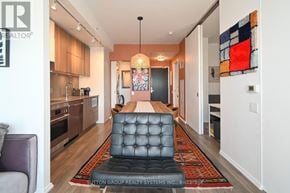 Toronto (Waterfront Communities) condo for rent - A modern kitchen with a black tufted bench in the middle of the room.