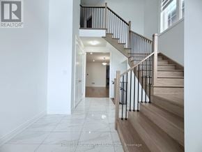 Whitchurch-Stouffville (Stouffville) apartment for rent - A spacious hallway with a staircase leading to the upper floor.