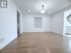 Whitchurch-Stouffville (Stouffville) apartment for rent - A spacious room with wooden flooring and a window with blinds.