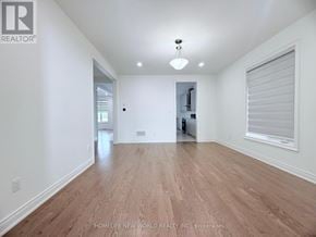 Whitchurch-Stouffville (Stouffville) apartment for rent - A spacious room with wooden flooring and white walls.