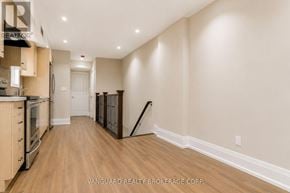 Toronto (Dovercourt-Wallace Emerson-Junction) townhouse for rent - A spacious kitchen with wood flooring and a white door in the background.
