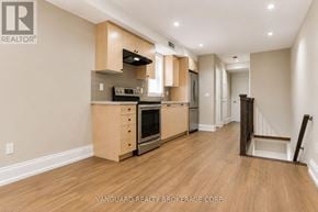 Toronto (Dovercourt-Wallace Emerson-Junction) townhouse for rent - A kitchen with wooden floors and a white ceiling.