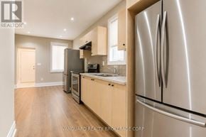 Toronto (Dovercourt-Wallace Emerson-Junction) townhouse for rent - A modern kitchen with a refrigerator on the right side.