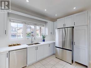 Brampton (Bram East) apartment for rent - A modern kitchen with white cabinets and a stainless steel refrigerator.