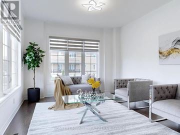 Brampton (Bram East) apartment for rent - A living room with a glass coffee table and a grey sofa.