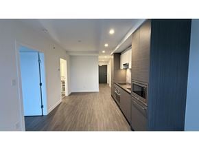 Surrey apartment for rent - A modern kitchen with dark wood cabinets and a white wall.