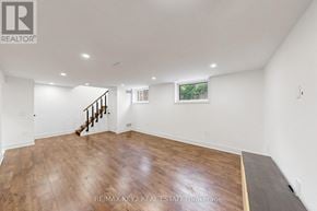 Whitby (Downtown Whitby) apartment for rent - A spacious room with wooden flooring and a staircase leading to another level.