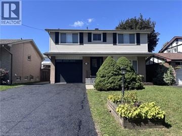 Hamilton apartment for rent - A house with a garage and a driveway in front of it.